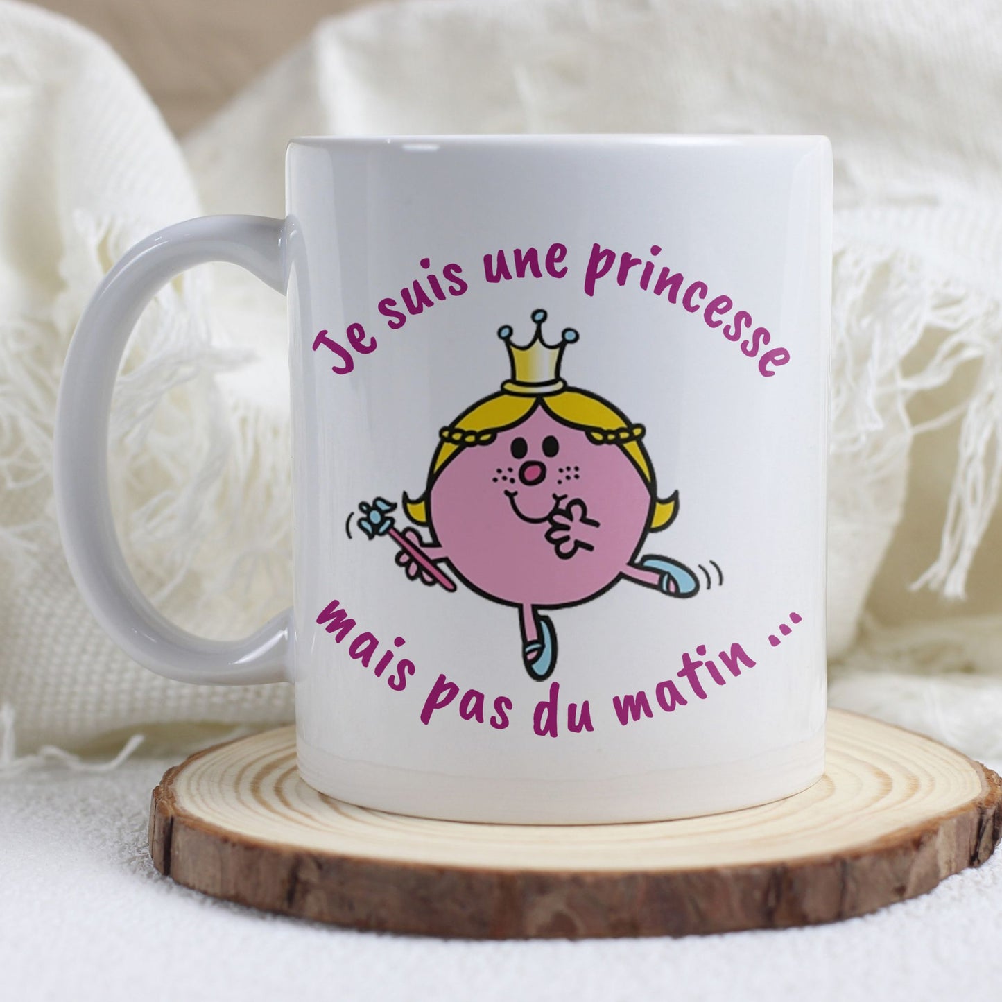  Mug humoristique "Je suis une princesse, mais pas du matin" posé sur une table avec une tasse de café fumante.