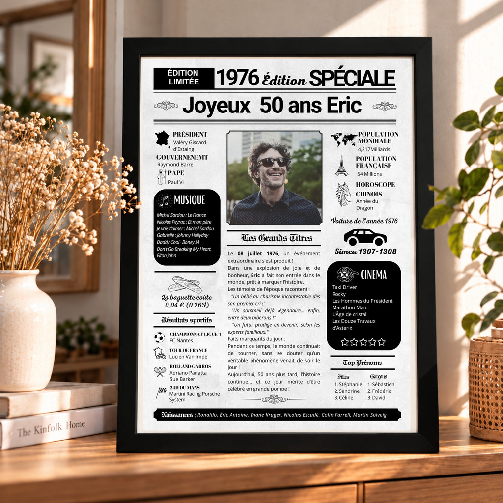 Affiche journal des 50 ans présentée dans un cadre noir, sur un meuble en bois dans un intérieur chaleureux.